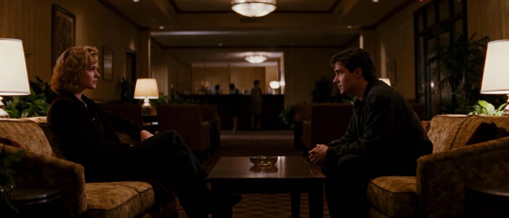 Man woman sitting in hotel lounge looking at each other